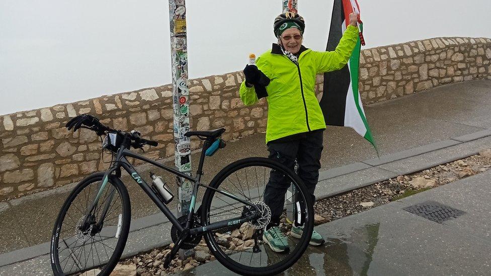 Anne Jones surrounded by fog holding a Palestinian flag