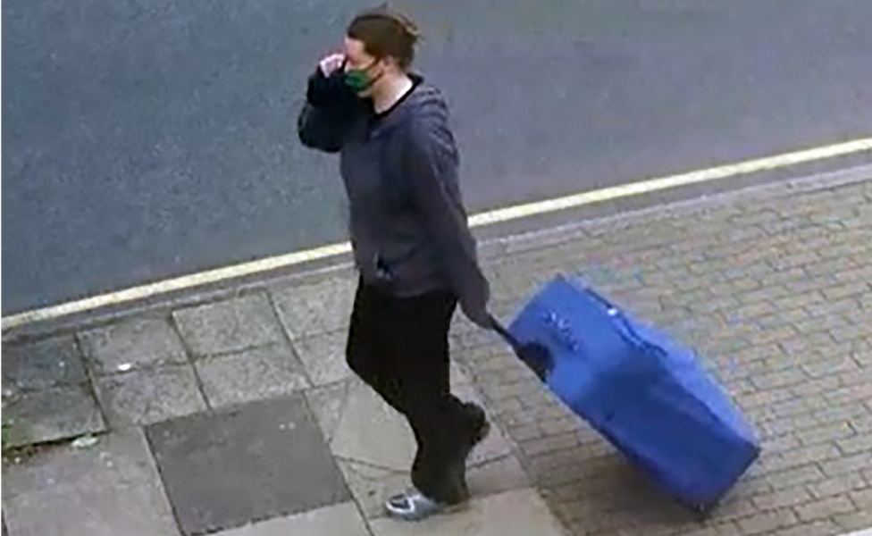 Jemma Mitchell pulling a blue suitcase through the streets of London