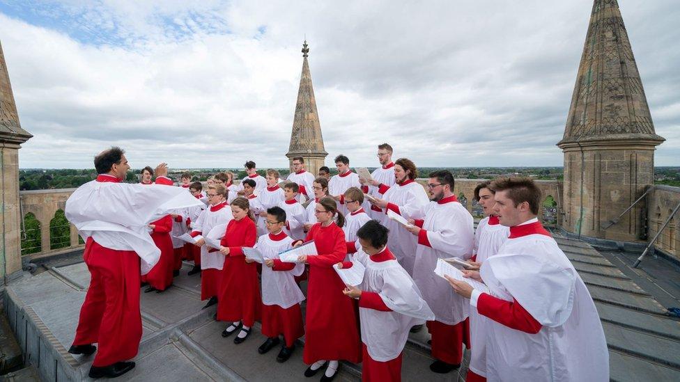 The St John's choir performs on the top of the chapel's tower