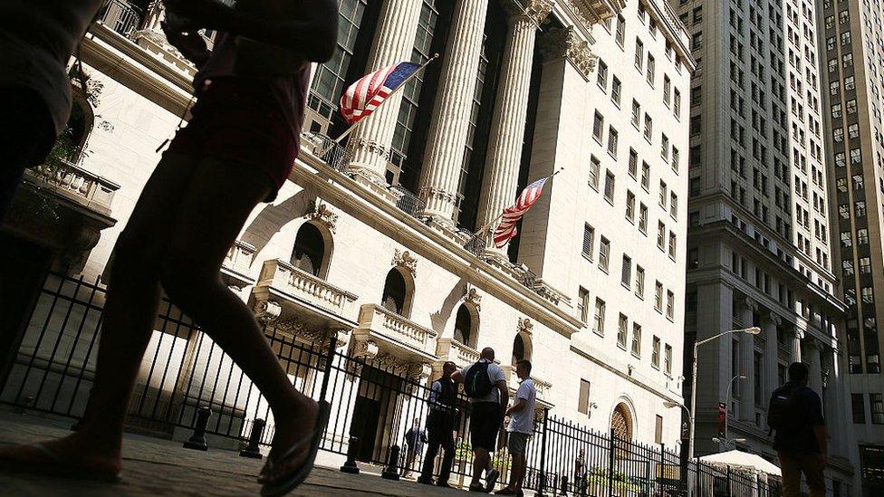 People walk by the New York Stock Exchange