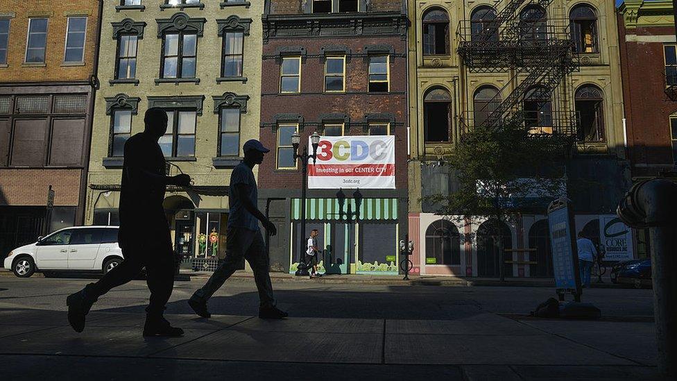 Two men walk by a building slated for redevelpment by the Cincinnati Center City Development Corporation