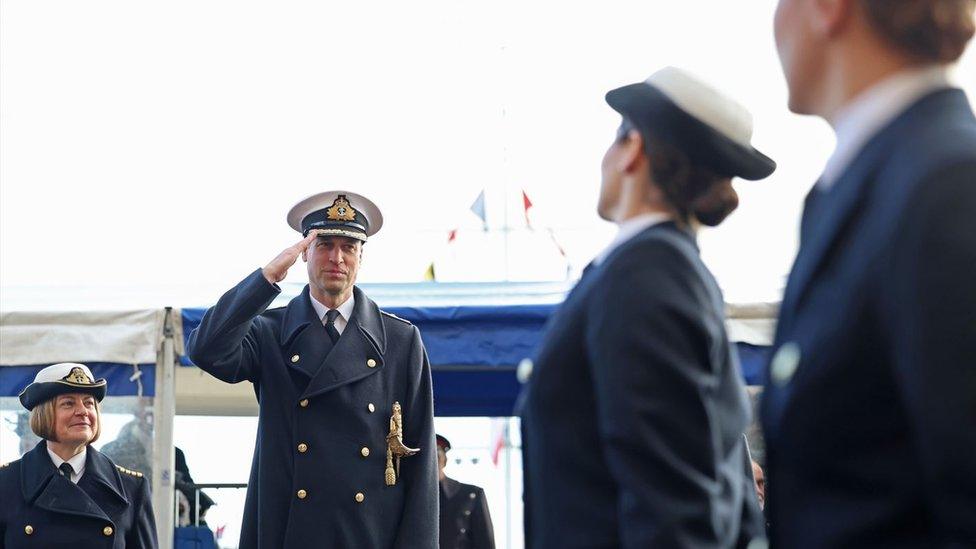 The prince salutes as the new officers pass him