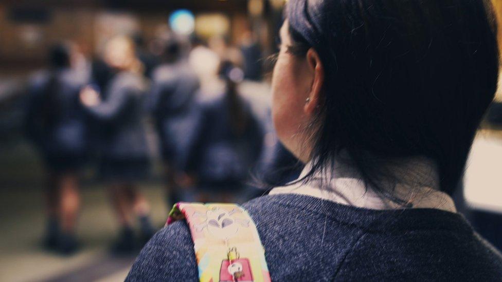 Pupil walks through school corridor