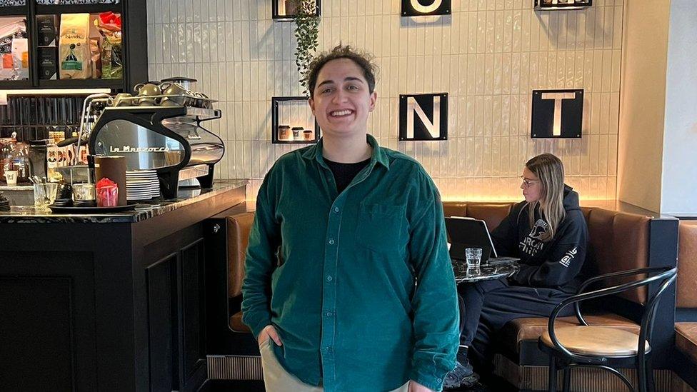 Ines standing in front of the counter smiling at the camera