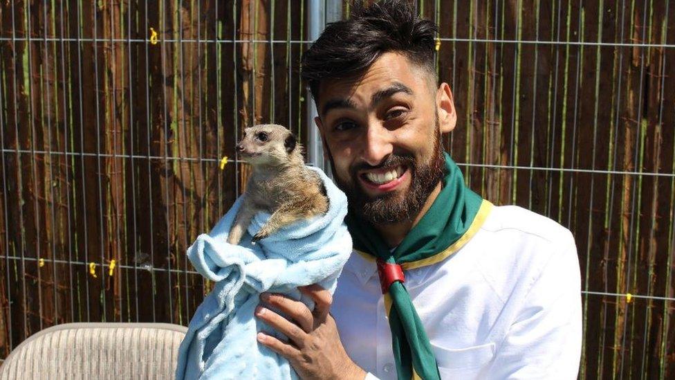 One of the young scout leaders holding a meerkat