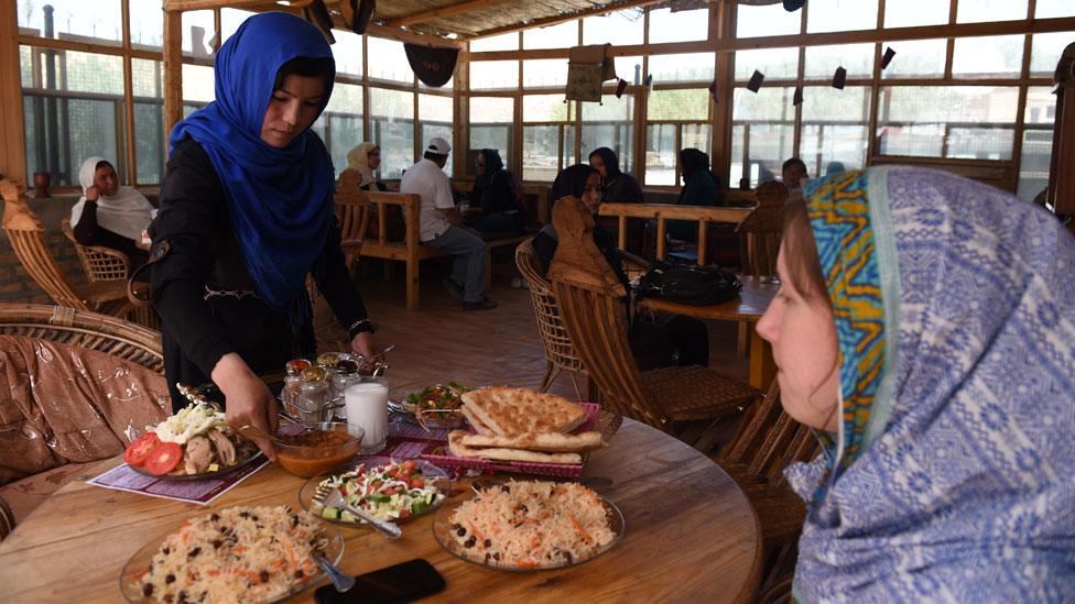 A Hazara Afghan waiter delivers the food ordered by customers at the Women's Tea House in Bamiyan