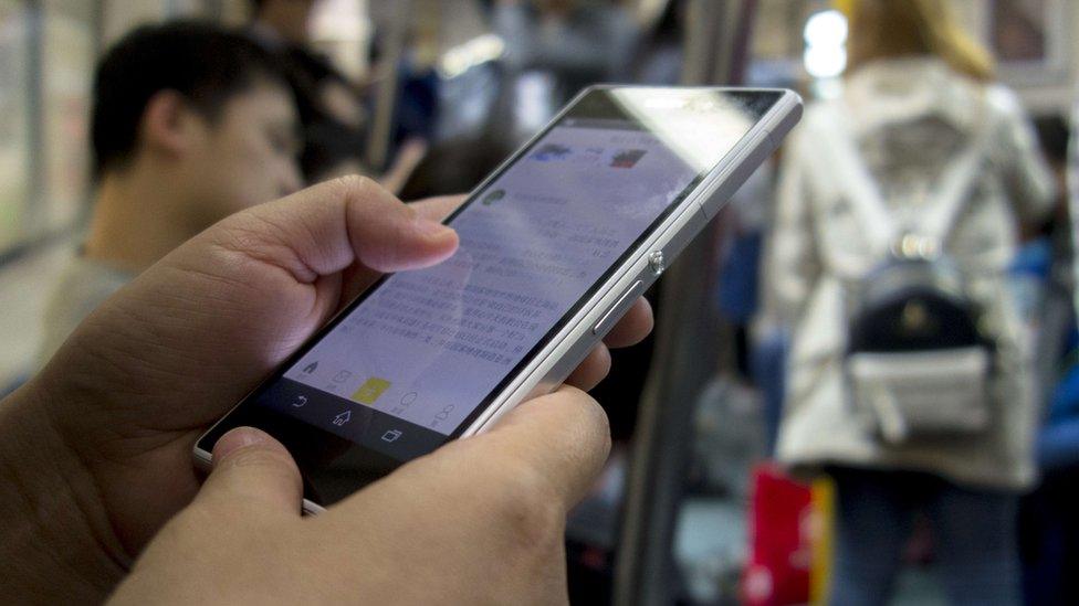 Close-up of someone reading their phone on train in China