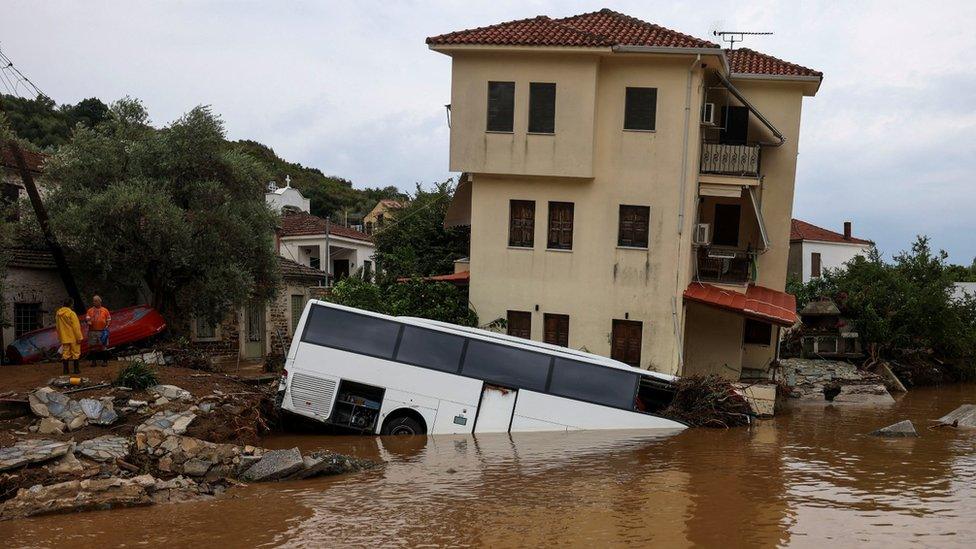 A bus and house are partially submerged following flash floods as storm Daniel hits central Greece