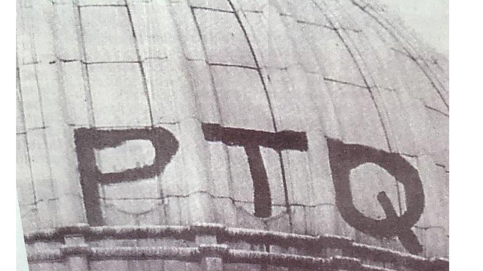 In the summer of 1964, three students from the Belfast College of Technology hid in Belfast City Hall, armed with paint and brushes. During the night, they scaled the building and painted PTQ on the roof