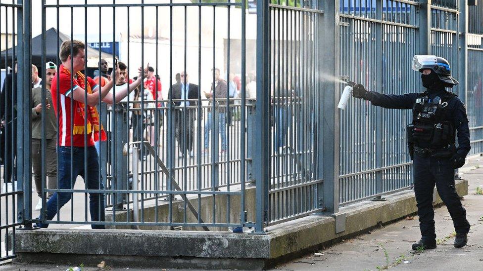 Police officer using CS spray on a Liverpool fan