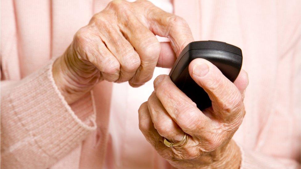 elderly person with phone in hand