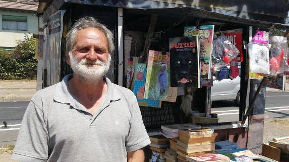 Christian Gostling poses for a photo outside his book kiosk