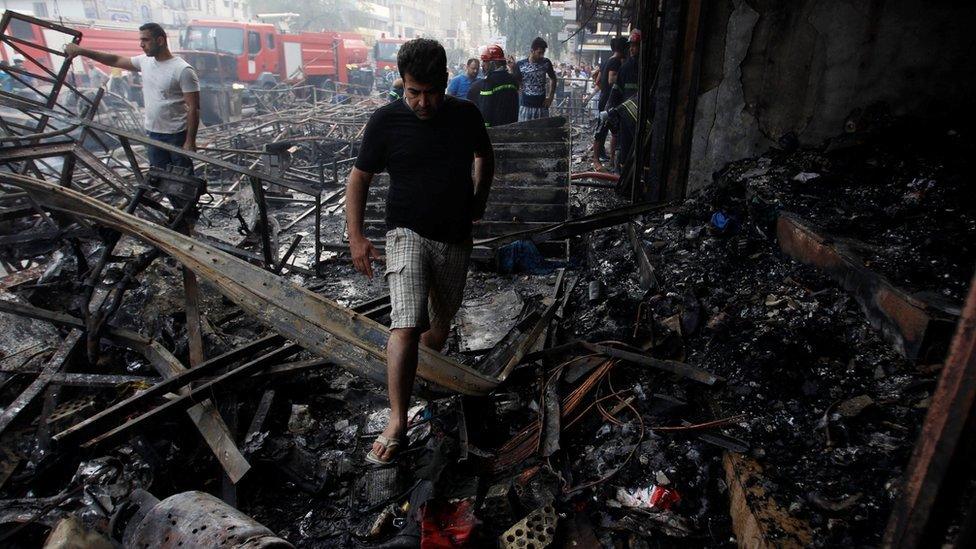 People gather at the site of a suicide car bomb in the Karrada shopping area, in Baghdad, Iraq July 3, 2016