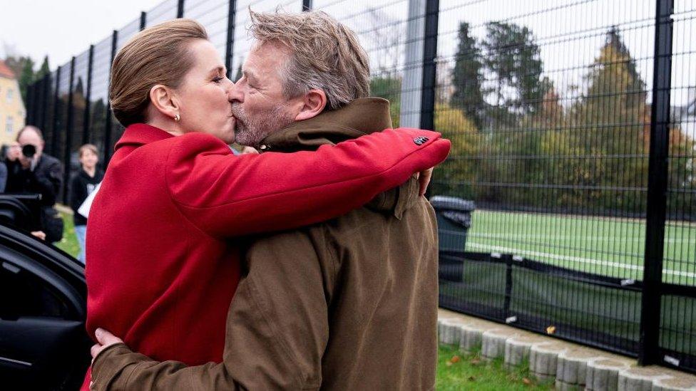 Denmark's Prime Minister and head of the the Social Democratic Party Mette Frederiksen and her husband Bo Tengberg kiss after casting their votes during the general election at Hareskovhallen, in Vaerloese, Denmark,