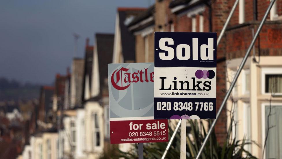 Houses in North London with for sale and sold signs outside