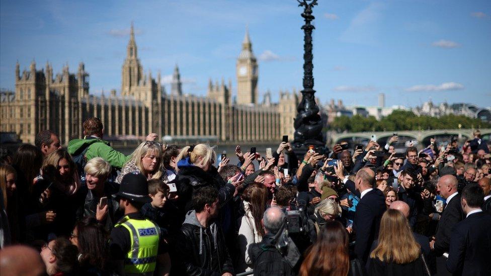 People take pictures of Prince William