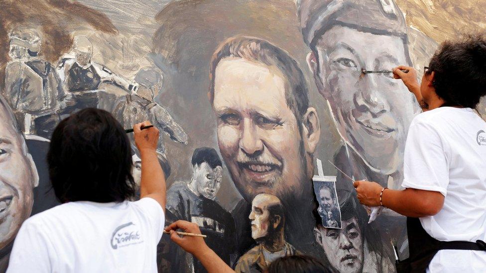 Painters work on a mural in Thailand featuring cave rescuers including Richard Harris and Saman Gunan, the Thai diver who died during the operation