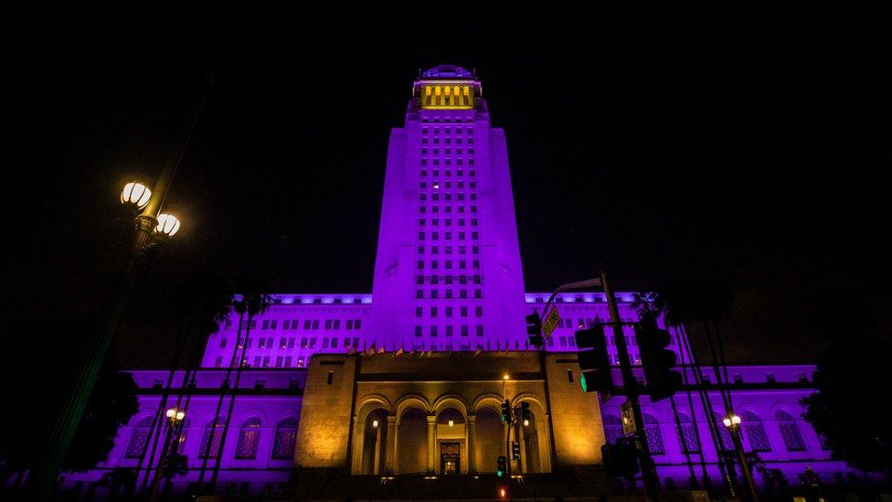 city_hall_building_lit_up_in_purple_and_yellow