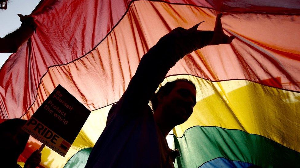 People hold a flag at a Pride parade in Bangalore