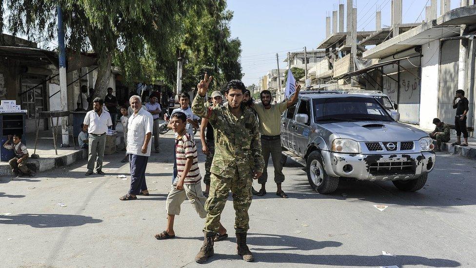 Members of Turkish-backed Free Syrian Army (FSA) flash V-signs as they control the border town of Jarablus, Syria