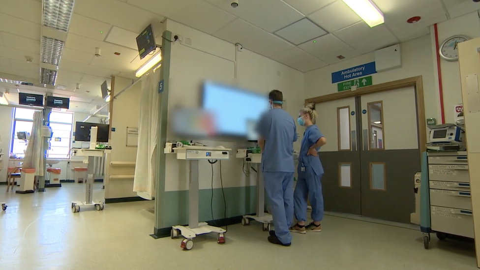 Hospital scene, with medic looking at screen