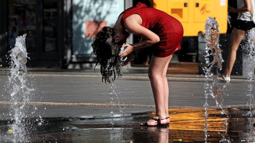 A woman cools off in a fountain in Cordoba on 29 June 2015