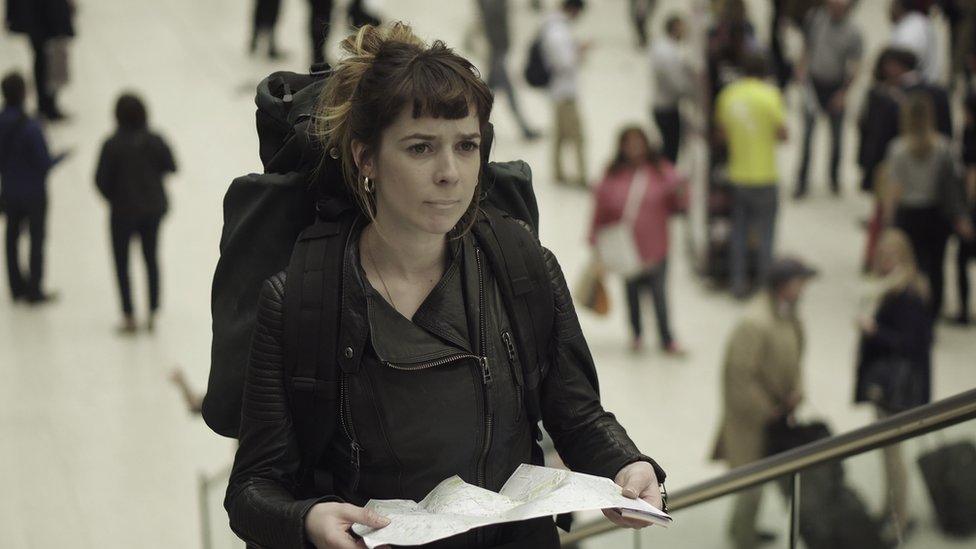 A woman holding a map in a train station