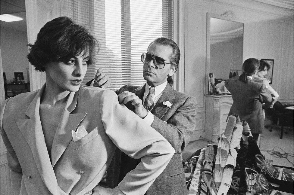 Karl Lagerfeld fits one of his designs on top model Ines de la Fressange at Chloe's Paris studio.