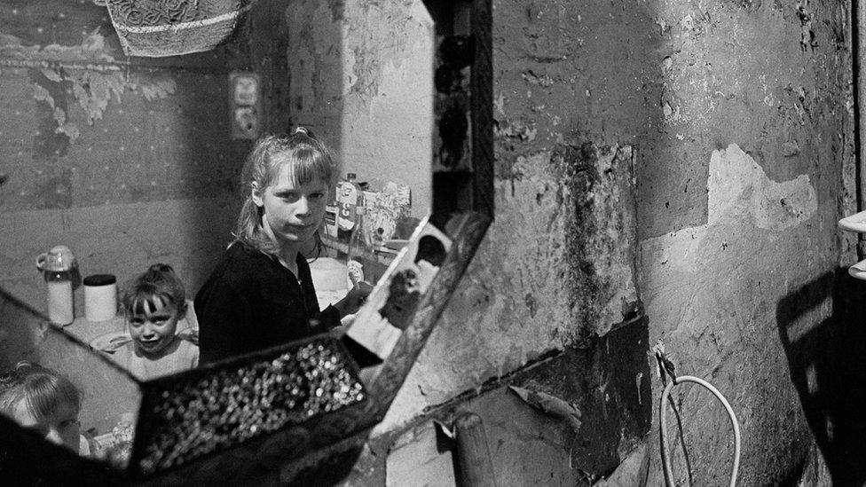 Pauline Rump and her younger sister reflected in a mirror, Rothschild Dwellings, Whitechapel 1969