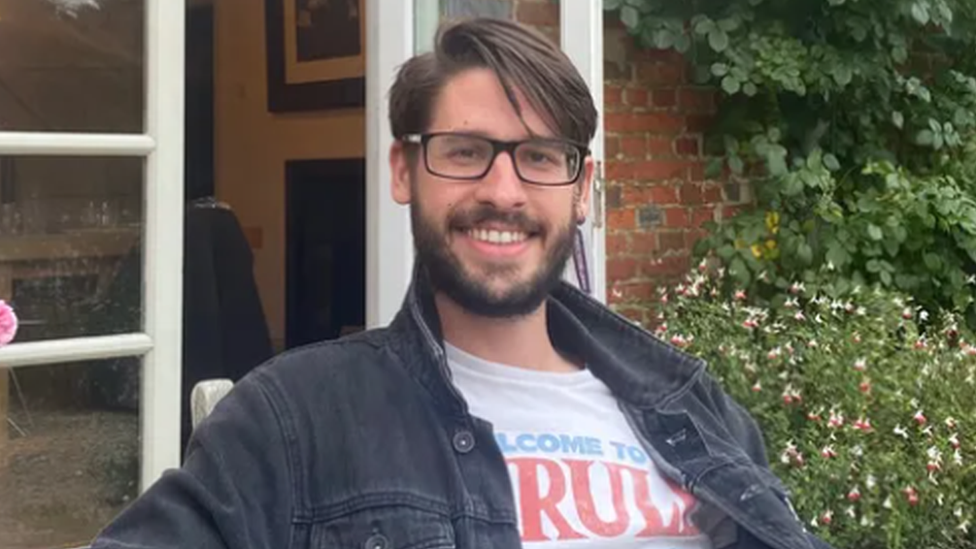 Vincent Le Goascoz smiling at the camera as he sits outside a building