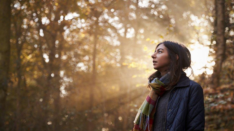 Woman in a forest with autumnal trees