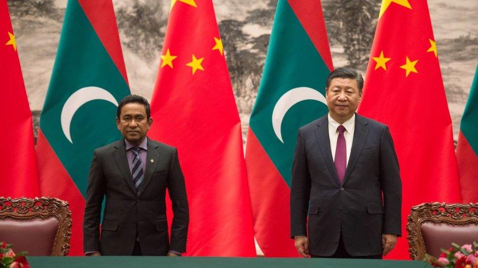 Abdulla Yameen (L) stands with China's President Xi Jinping during a signing ceremony at the Great Hall of the People in Beijing on December 7, 2017