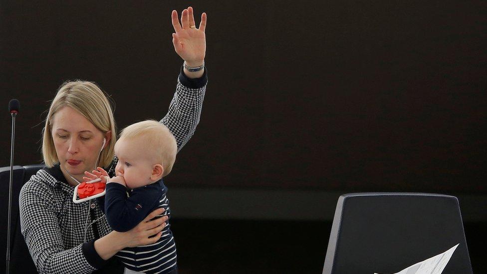 Swedish Member European Parliament Jytte Guteland holds her baby as she takes part in a voting session at the European Parliament in Strasbourg, France.