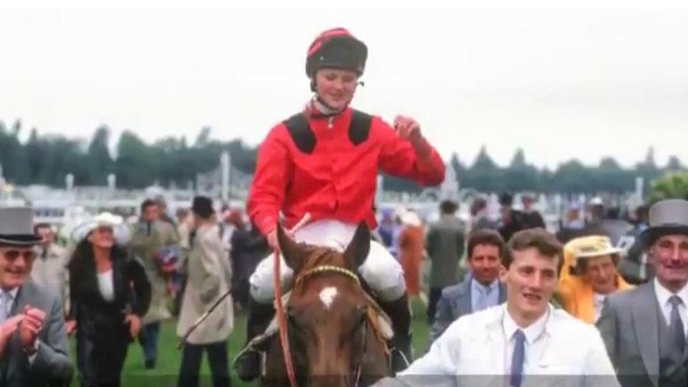 Gay Kelleway - female jockey in red silks on a chestnut brown horse called Sprowston Boy.