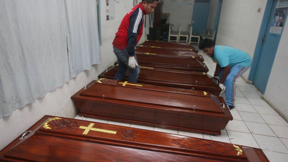 Workers prepare coffins for the victims of the eruption of Mt. Sinabung at a hospital in Kabanjahe, North Sumatra, Indonesia, Sunday, 22 May 2016.