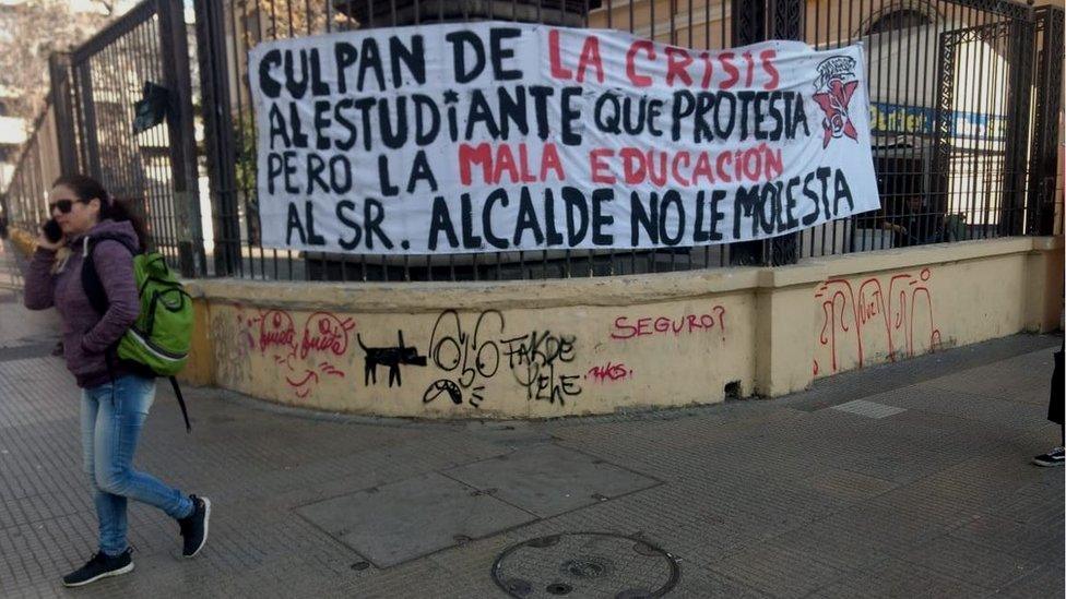 A placard reads: "They blame the protesting pupils for the crisis but bad education does not bother the mayor."