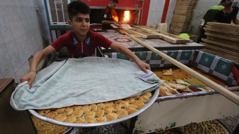 Iraqis prepare pastries known as Kliga ahead of the Eid al-Fitr Muslim festival