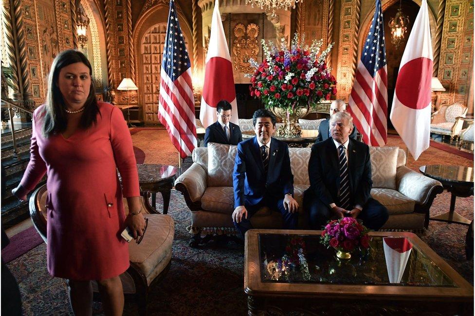 US President Donald Trump greets Japanese Prime Minister Shinzo Abe as he arrives for talks at Trump's Mar-a-Lago resort in Palm Beach, Florida, on 17 April 2018. White House Press Secretary Sarah Sanders is at left