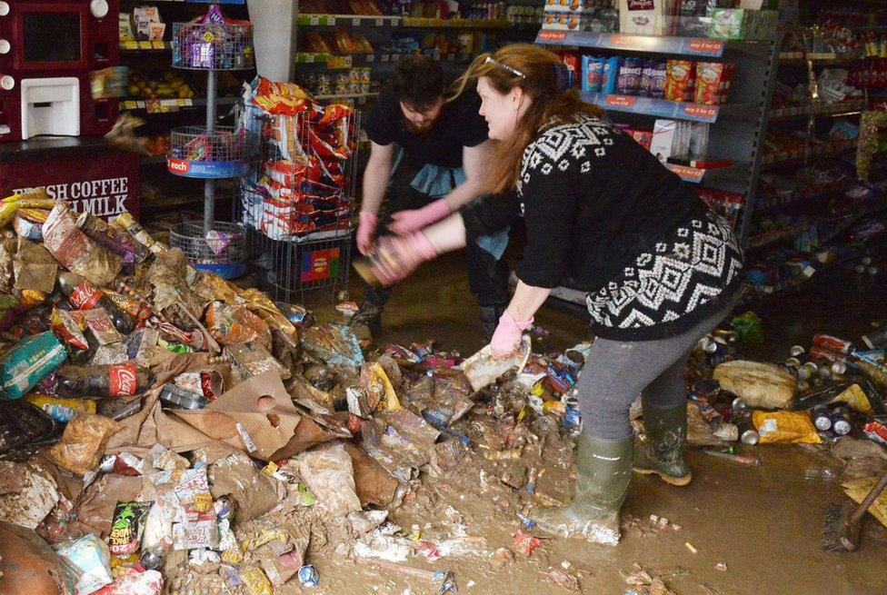 Shop workers clearing rubbish from a flooded store in Cockermouth in December, 2015