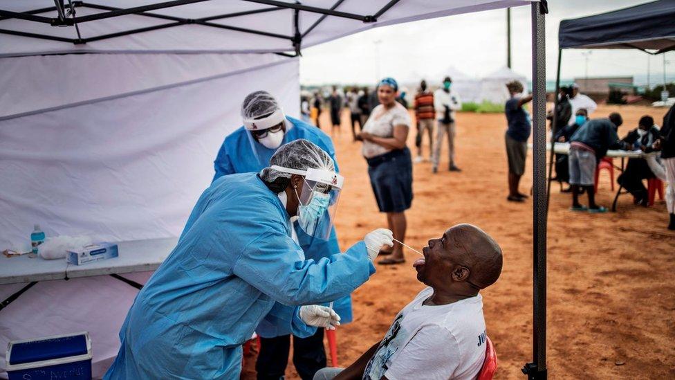 A man, a resident of the sprawling township of Alexandra in Johannesburg, opens his mouth to receive a testing swab for COVID-19 coronavirus at a screening and testing drive in front of the Madala Hostel, on April 27, 2020.