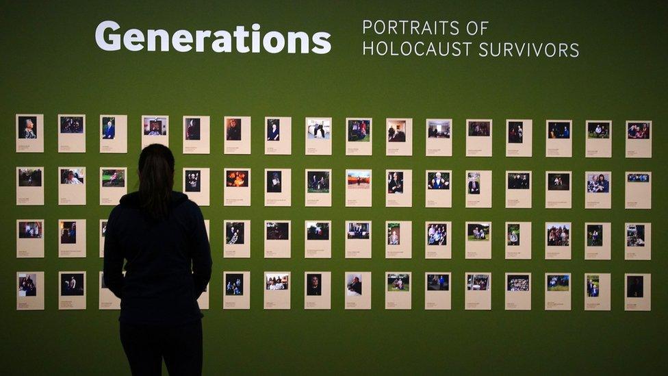 A person looks at the Generations portraits