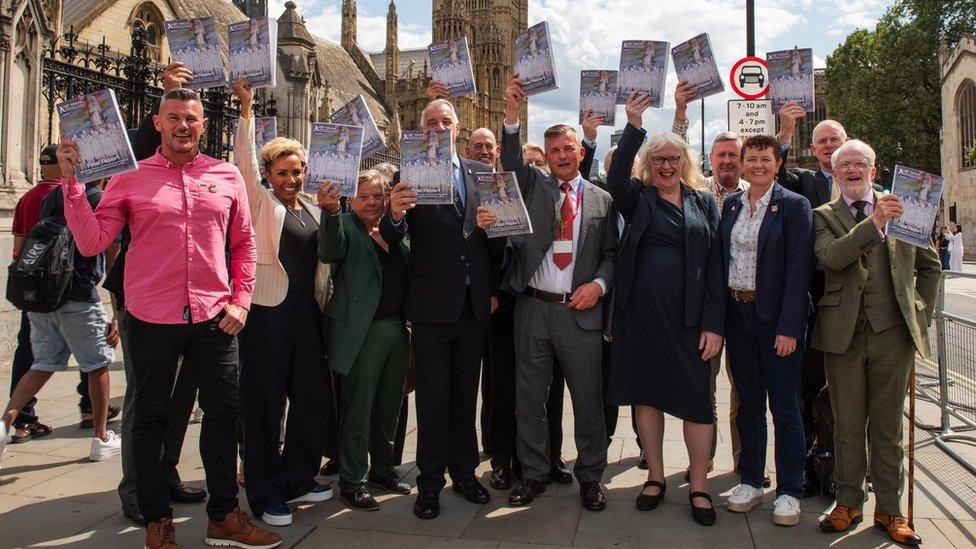 A group of veterans celebrate outside parliament