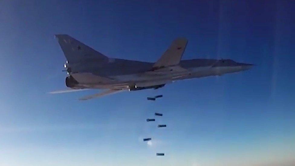 A Tu-22M3 long-range bomber releasing its payload above Syria.