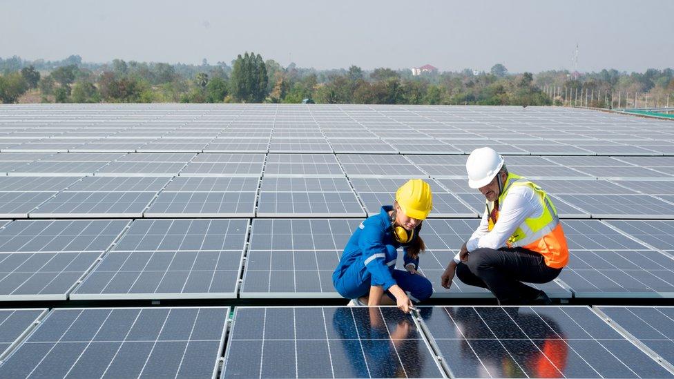 People inspecting a solar panel.