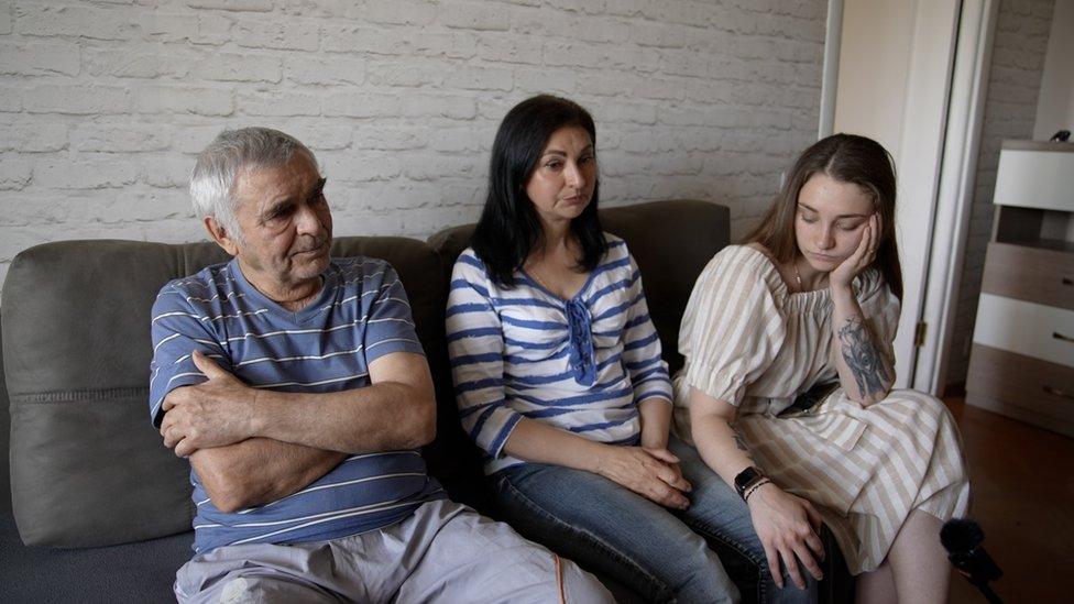 A man and two women sitting on a sofa