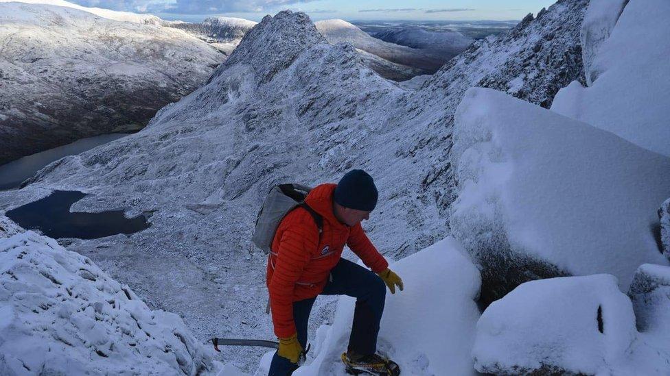 Calum yn mentro'r Gribin a Tryfan yn y pellter