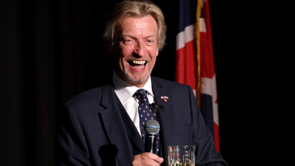 Lythgoe smiles at a lectern