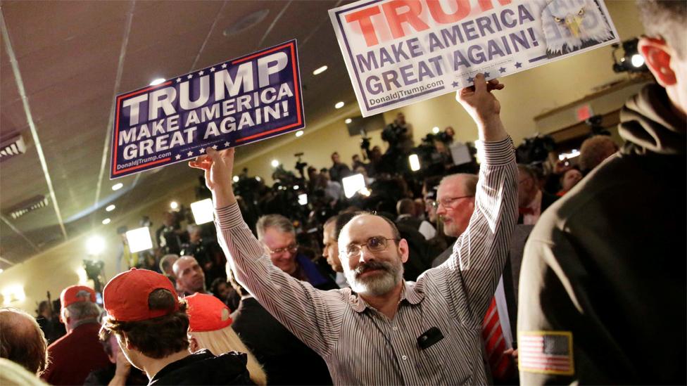 Frank Ricci, of Providence, R.I., holds signs supporting Republican presidential candidate, businessman Donald Trump while supporters wait for Trump to attend a primary night rally, Tuesday, Feb. 9, 2016,