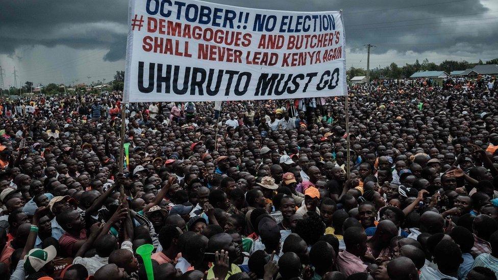 Supporters of Kenya"s opposition National Super Alliance (NASA) coalition hold a banner during a political rally in Kisumu, western Kenya, on October 20, 2017.