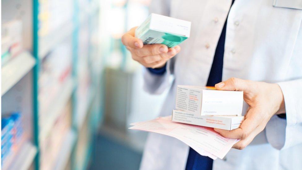 A pharmacist holding medicines